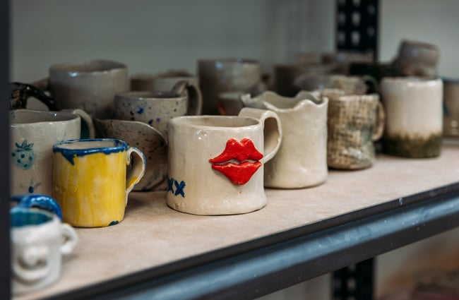 A close up of a pottery cup with red lips.