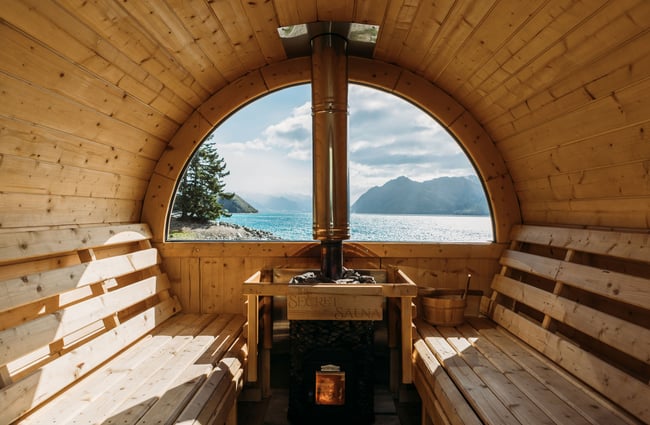 The inside view of a sauna looking out towards a lake.