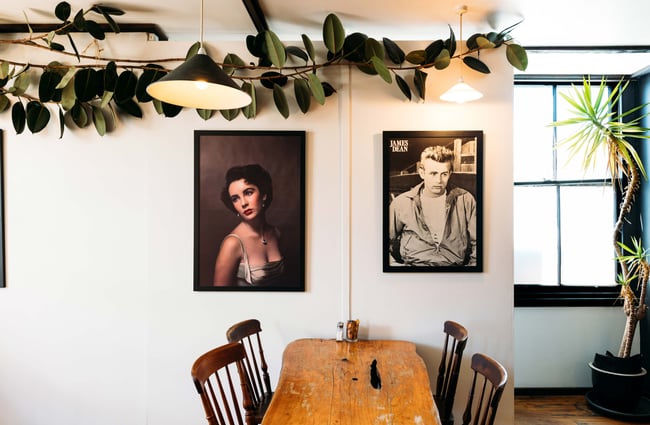 Black and white photos of James Dean and Elizabeth Taylor on a wall.