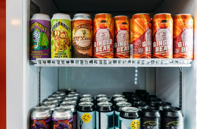 A close up of cans of beers in a fridge.