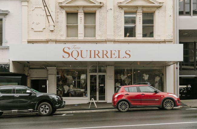 The exterior of Two Squirrels where there are cars parked on the roadside.