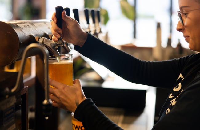 Woman pouring a pint of beer at Two Thumb Harbourside