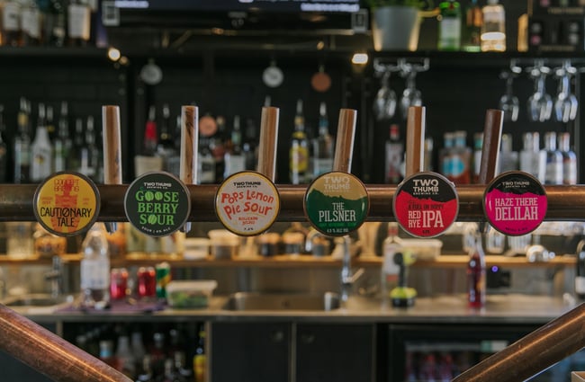 A close up of beer stickers on taps.