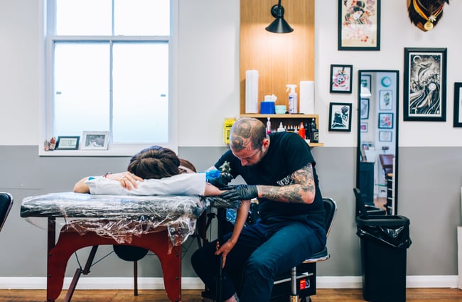A man tattooing at Union Tattoo, Wellington.