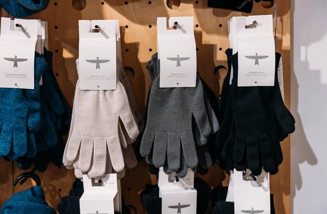 Merino gloves hung on a peg board at Untouched World in Wellington.