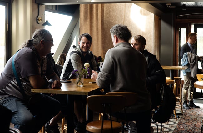 A group of men chatting a table in a pub.