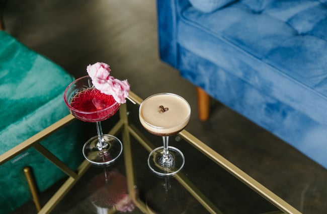 A close up of a pink cocktail and an espresso martini on a table.