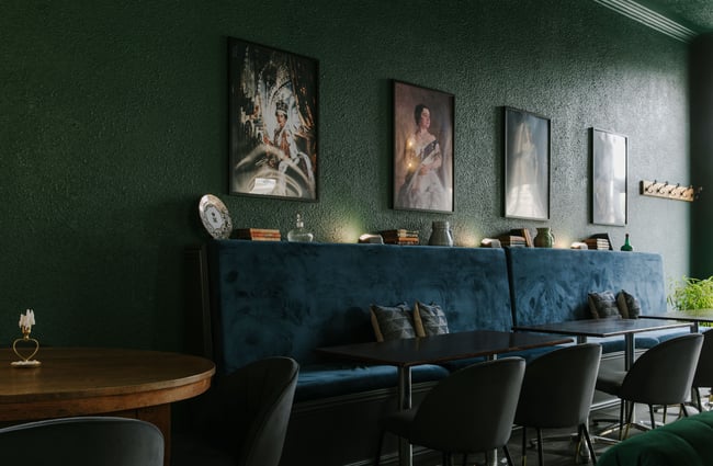 Luxurious blue seating inside a darkly lit bar.