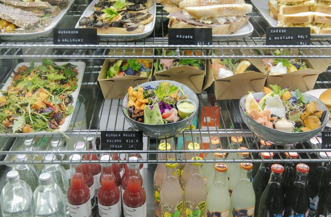 A close up of colourful looking salads inside a glass cabinet.