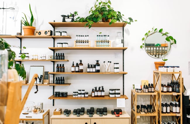 Beauty products and soaps on display on wooden shelves.