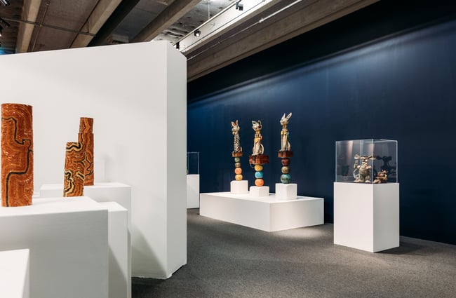 Ceramists on plinths in a large gallery.