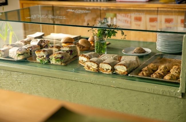 A close up of sandwiches in a glass cabinet.