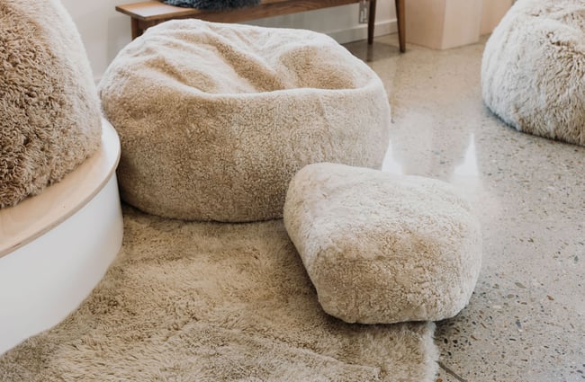 Close up of white sheepskin beanbag, cushion and rug.