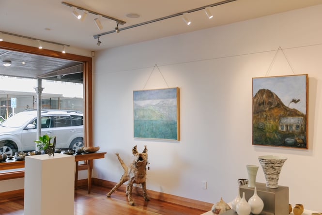 Paintings on the wall and sculptures on the ground inside Kiln Studio Nelson.