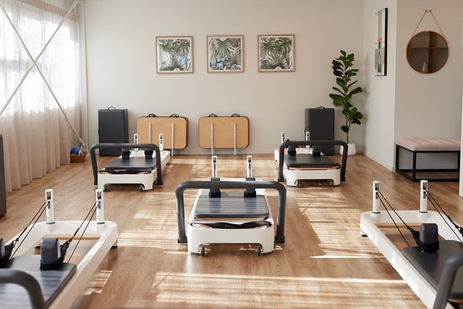 Reformer machines in a small Pilates studio.