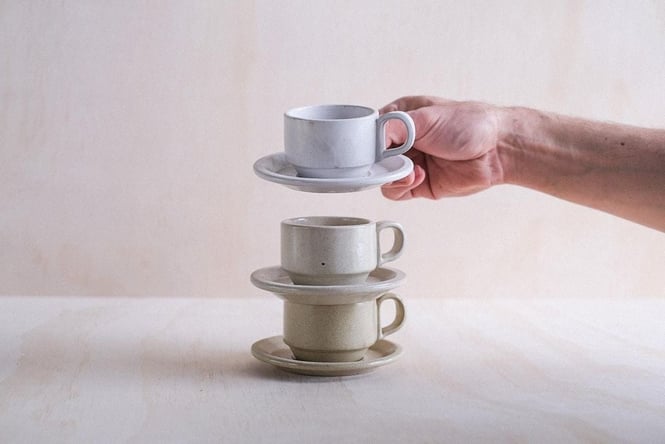 Three ceramic cups and saucers stacked on top of each other.