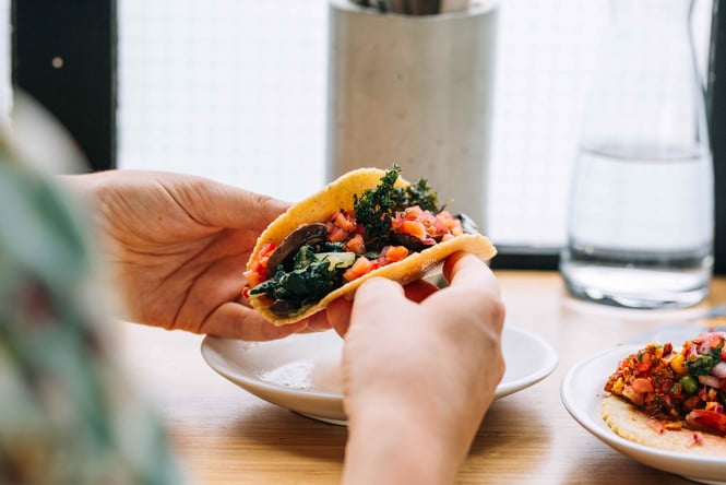 Hands holding a taco.