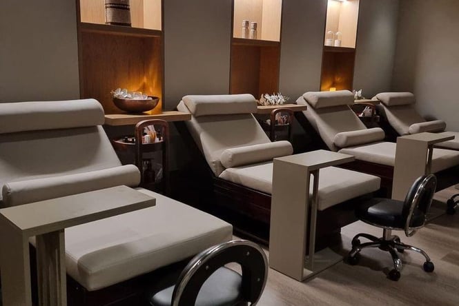 Row of reclined chairs in low-lit room at day spa in Auckland