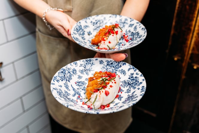 Two blue and white plates being held by a wait staff at Sugo.