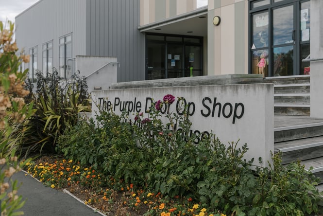 A large sign leading up to the Purple Door Op Shop.
