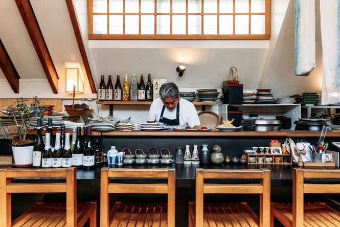 A chef working behind a counter inside the kitchen at Kappa Queenstown.