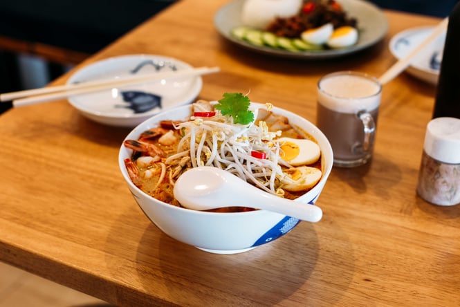 A bowl of laksa on a table.
