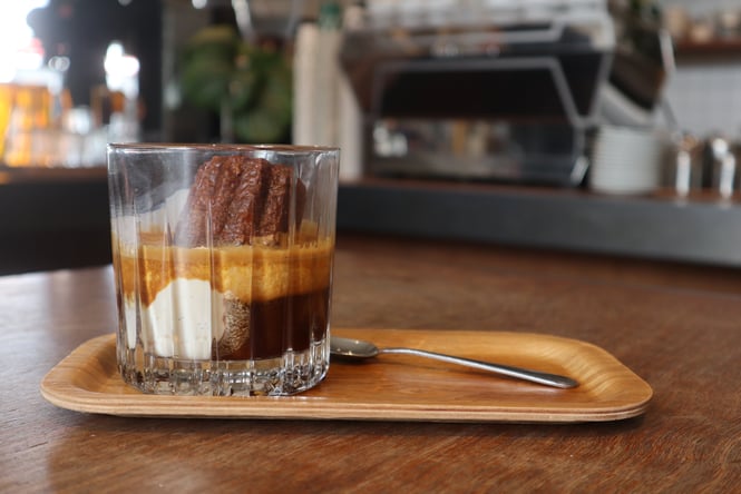 Close up of iced coffee with a canelé and scoop of vanilla ice cream inside