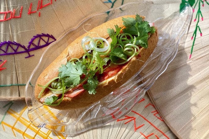 Fresh banh mi on a glass plate on top of traditional Vietnamese straw hats