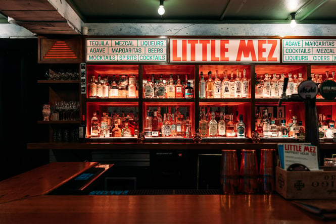 The bar at Little Mez lit up in red light.