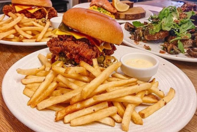 Neo Wellington fried chicken burger with a side of fries and aioli dipping sauce.