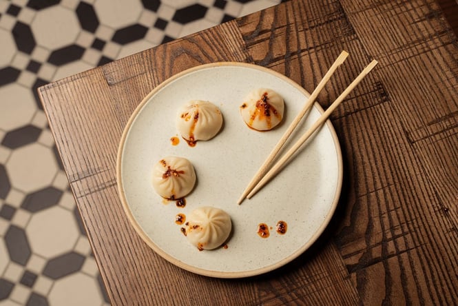 A plate of dumplings on a wooden table.