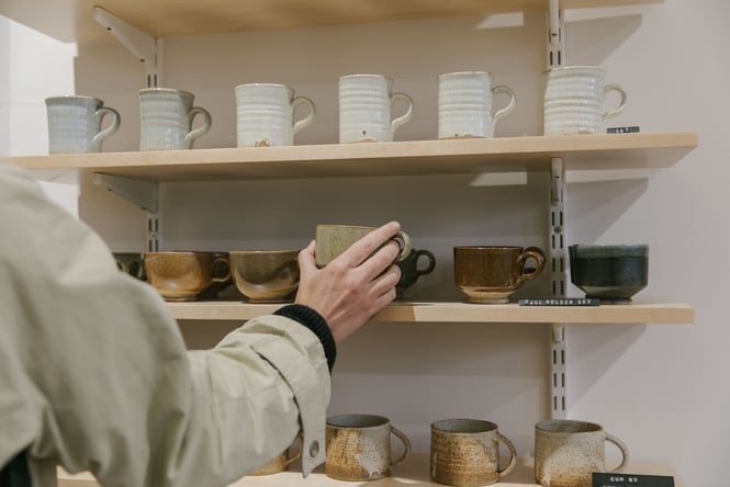 A hand holding a mug.