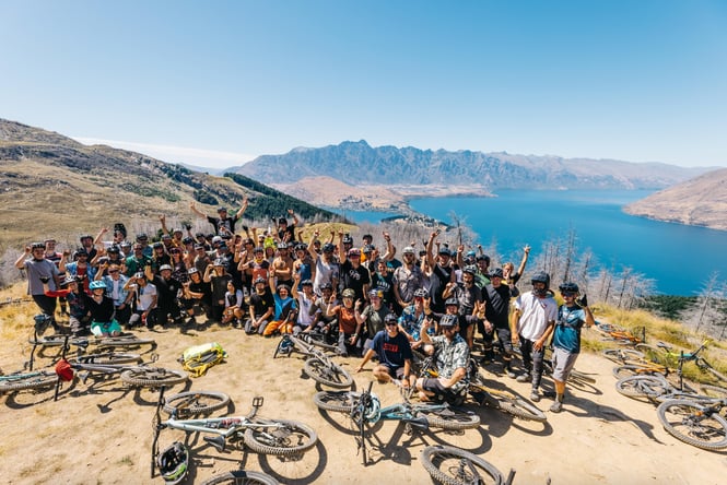 A large group of mountain bikers posing for camera.