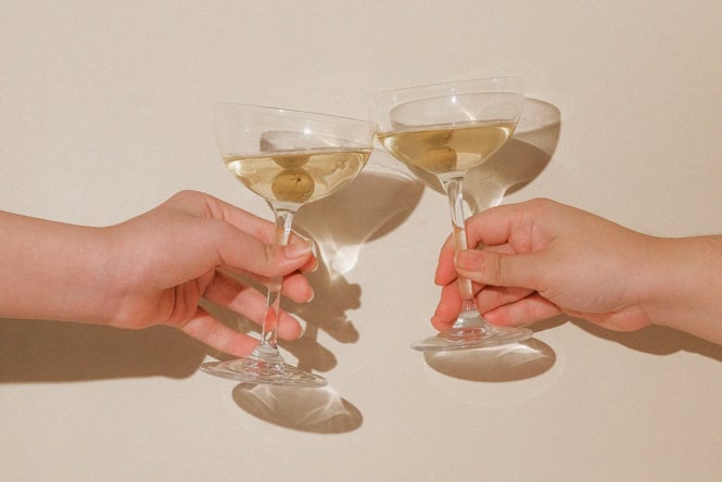 Two glasses of gin martinis toasting.