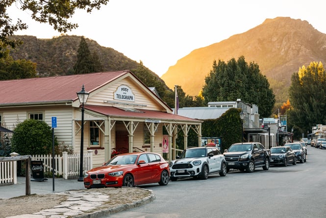 Old houses on an Arrowtown street at sunset.