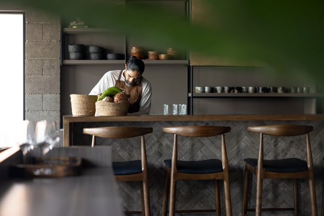 A staff member working behind a wooden bar at Tala in Auckland.