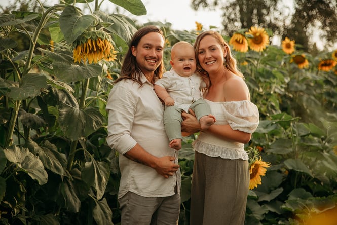 Kimi and Zane with their baby amongst the sunflowers.