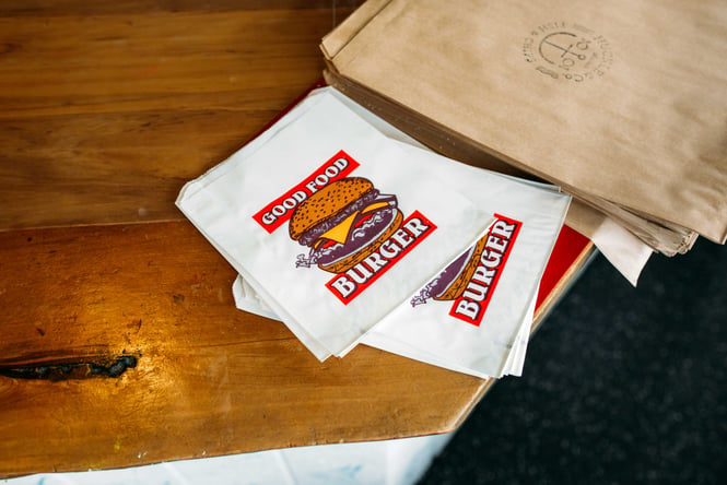 Paper bags with pictures of burgers on the front.