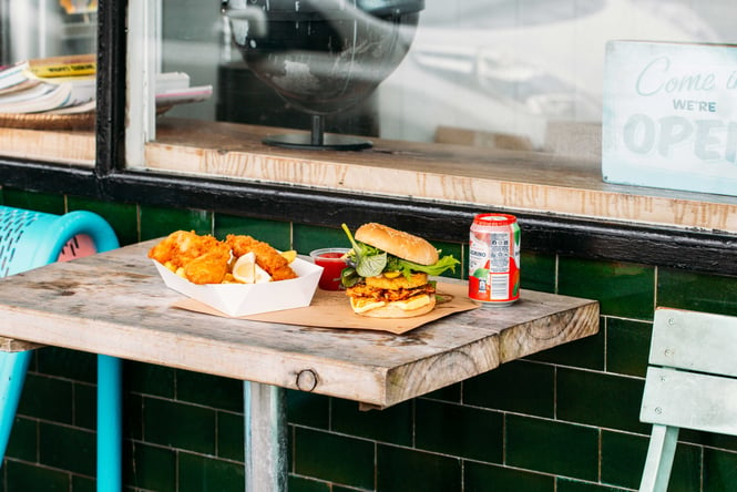 Fish and chips and burgers on a table.