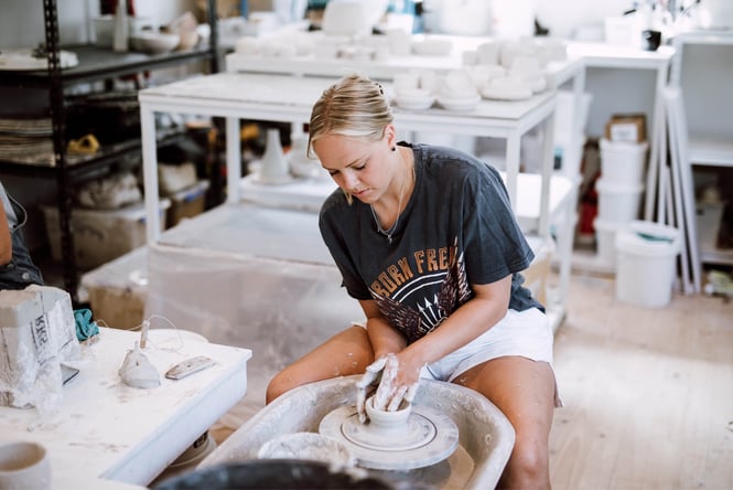 A young woman making pottery.