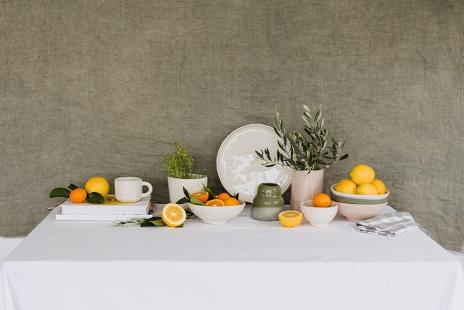 A beautiful table setting featuring ceramics and citrus.