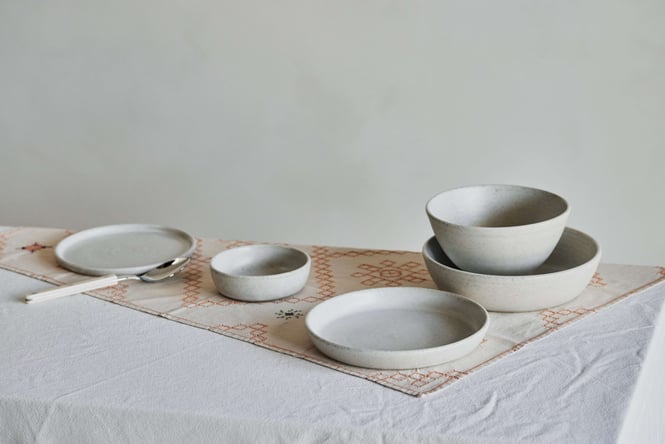 Salad Days ceramic bowls and plates on a table with a white table cloth.