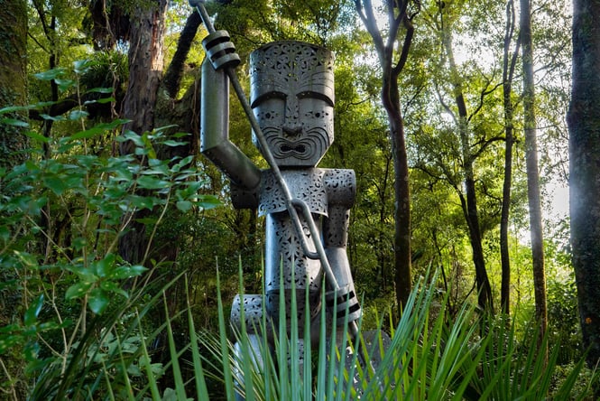 A Maori sculpture in amongst trees at Te Āpiti Manawatū Gorge.
