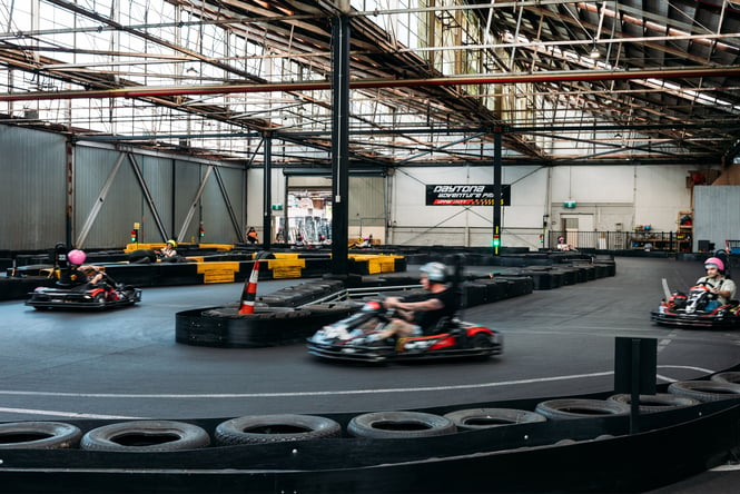 People in go karts racing around a track.