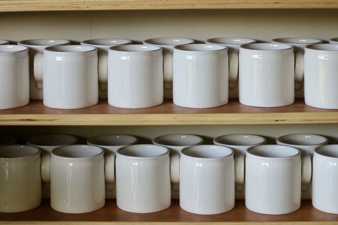 Taus cups lined up on shelves.