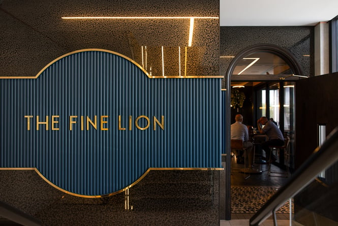 A blue and gold sign that says 'The Fine Lion'.