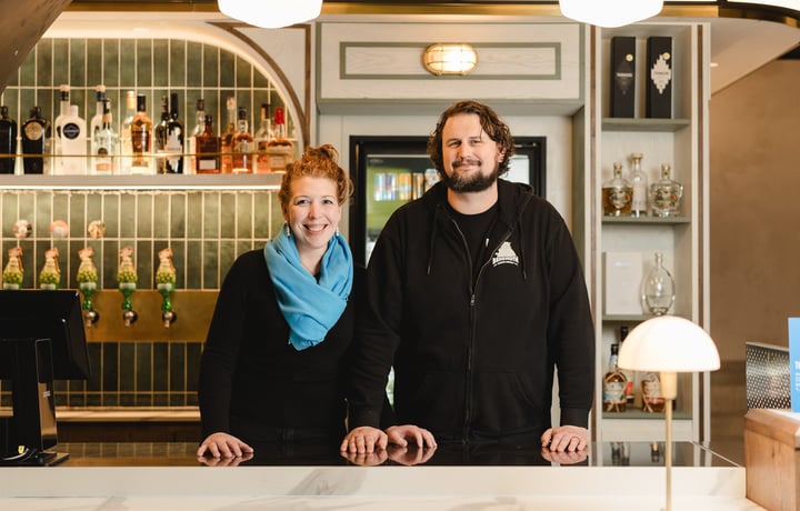 A man and woman standing behind a bar counter in Wellington.