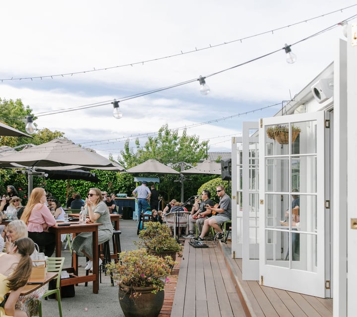Bi-fold white doors onto deck and courtyard area of Dux Dine in Christchurch.