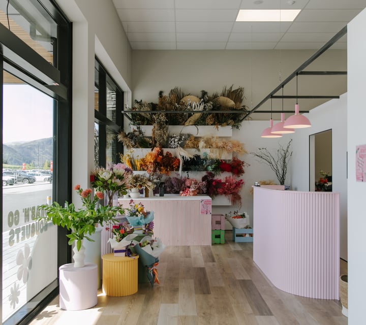 The interior of The Green Room flower and plant store with light pink counters.