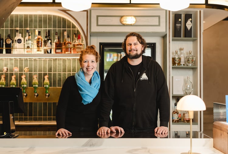 A man and woman standing behind a bar counter in Wellington.